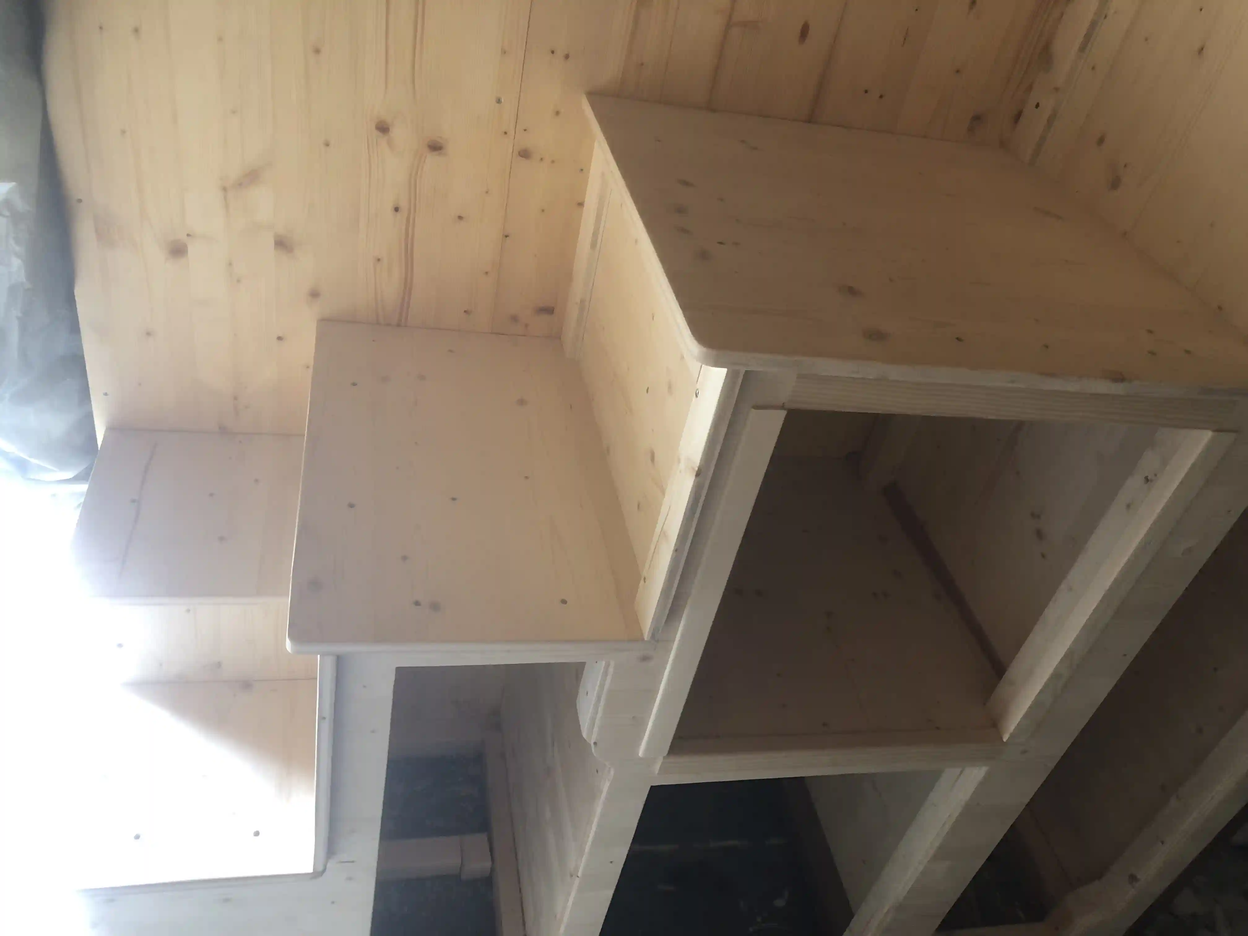 Die Außenhülle des Tiny Hauses mit abgeklebter Fassadenbahn und eingebauten Fenstern auf dem Anhänger